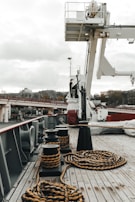 a boat deck with ropes on it and a crane in the background
