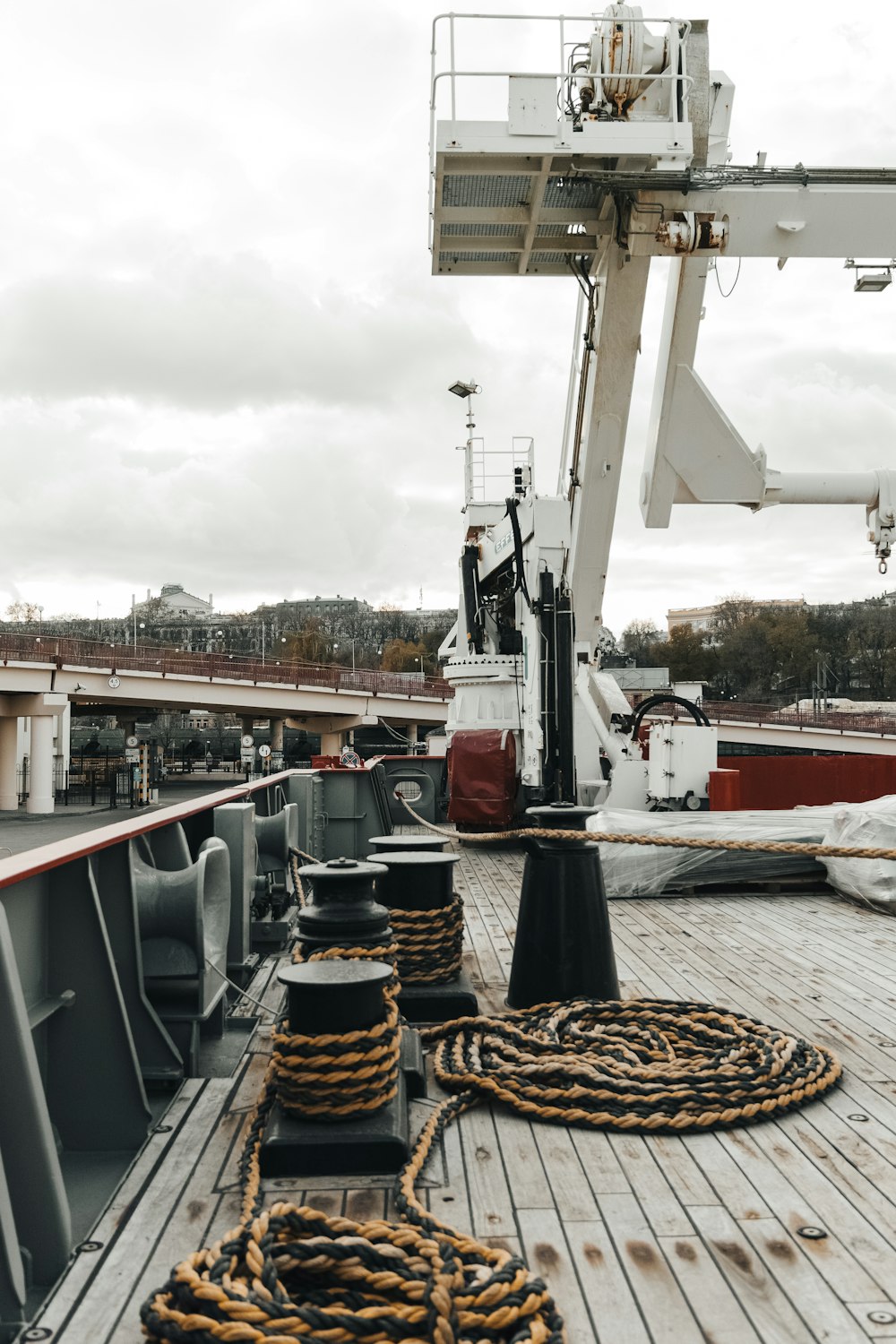 a boat deck with ropes on it and a crane in the background