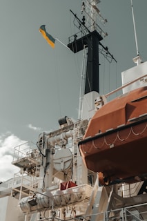 a large boat with a yellow flag on top of it