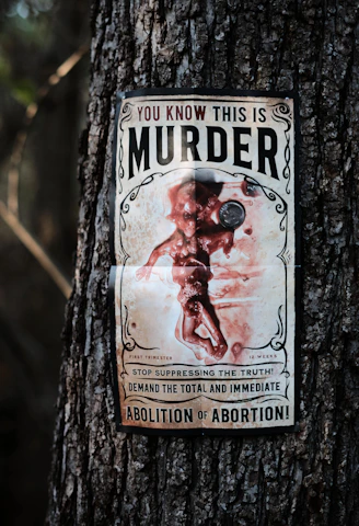 a sign on a tree that says you know this is murder