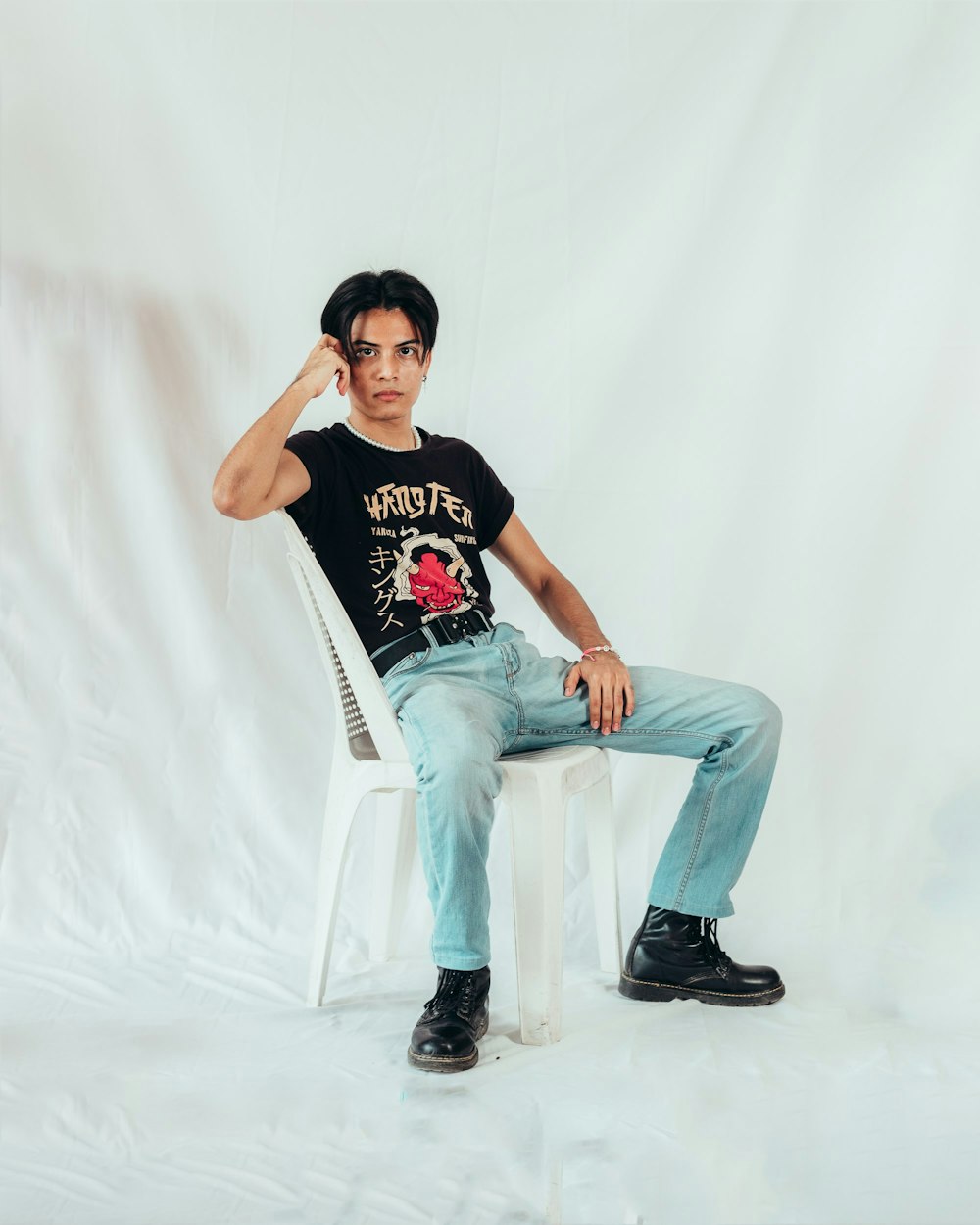 a man sitting on a white chair with his hand on his head