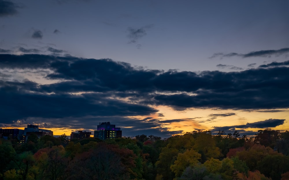 a view of a city at sunset with clouds in the sky