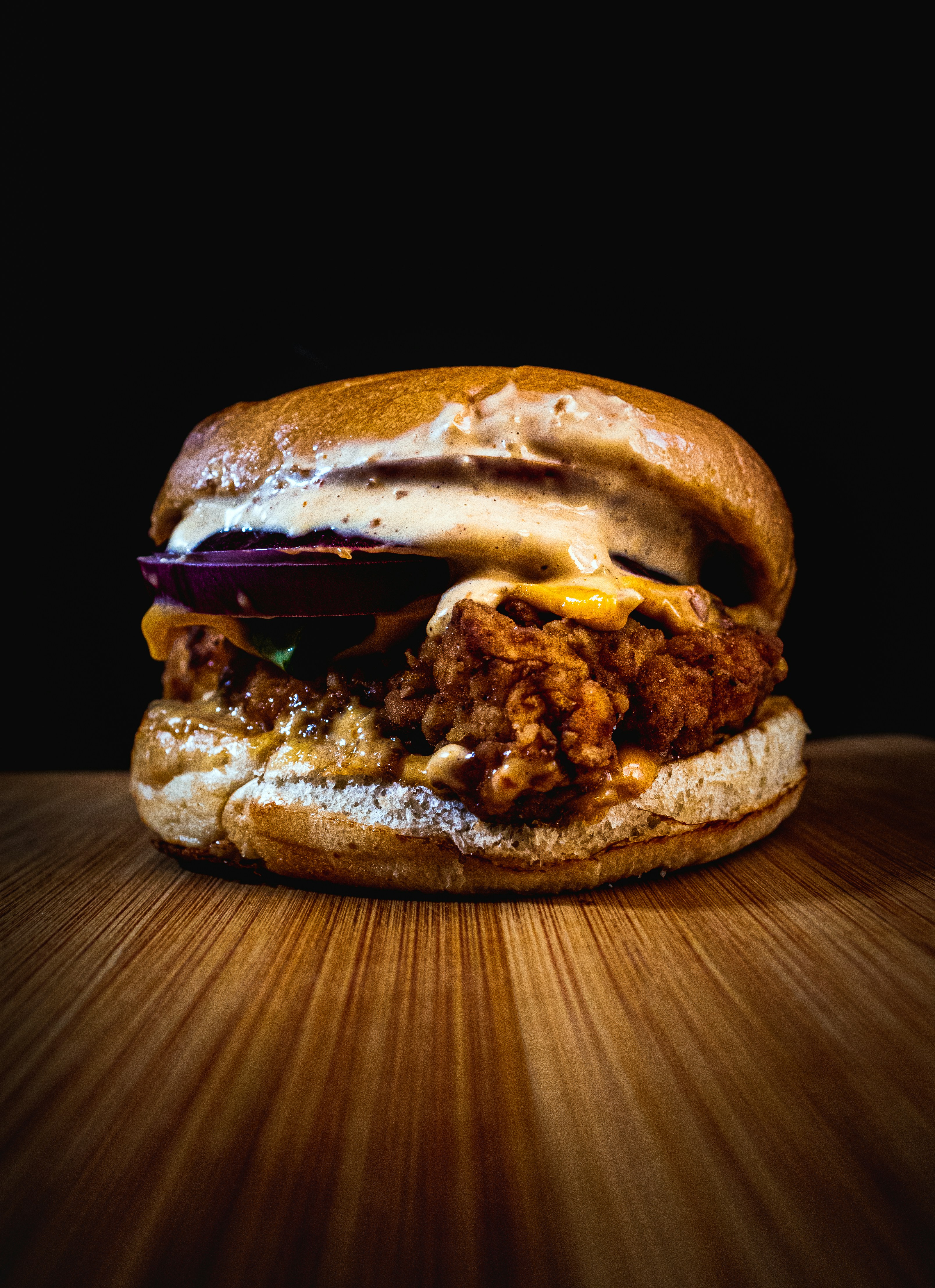 a fried chicken sandwich on a wooden table