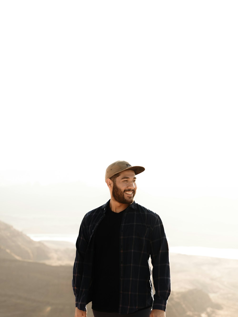 a man standing on top of a mountain with a beard