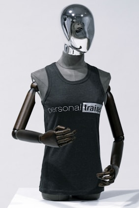 A sleek black and gold professional uniform displayed on a mannequin against a dark gradient background.