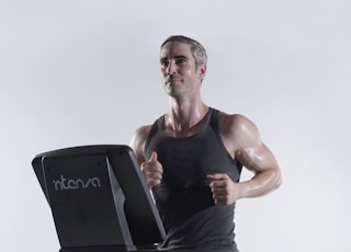 Fit guy, wearing an Intenza Unisex Tank, runs on an Intenza 450 Series Treadmill.