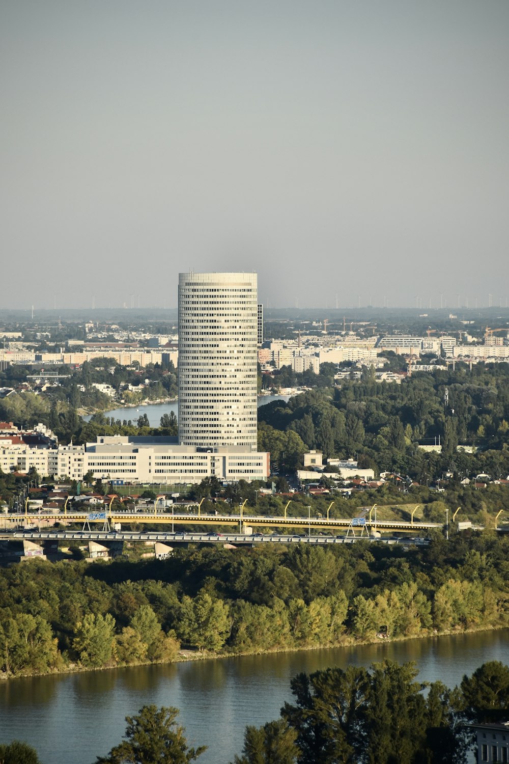 a tall white building sitting on top of a lush green hillside