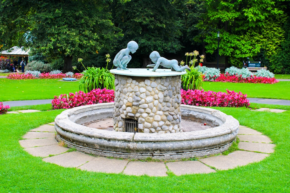 Una estatua de dos personas sentadas encima de una fuente