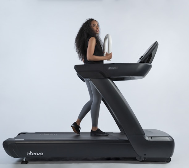 a woman is walking on a treadmill