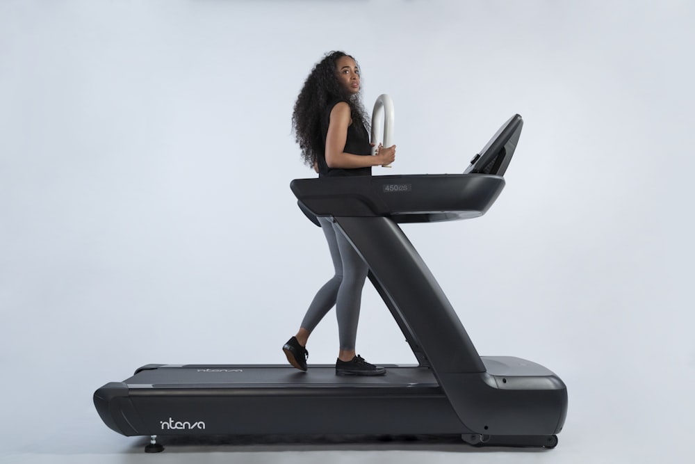 a woman is walking on a treadmill