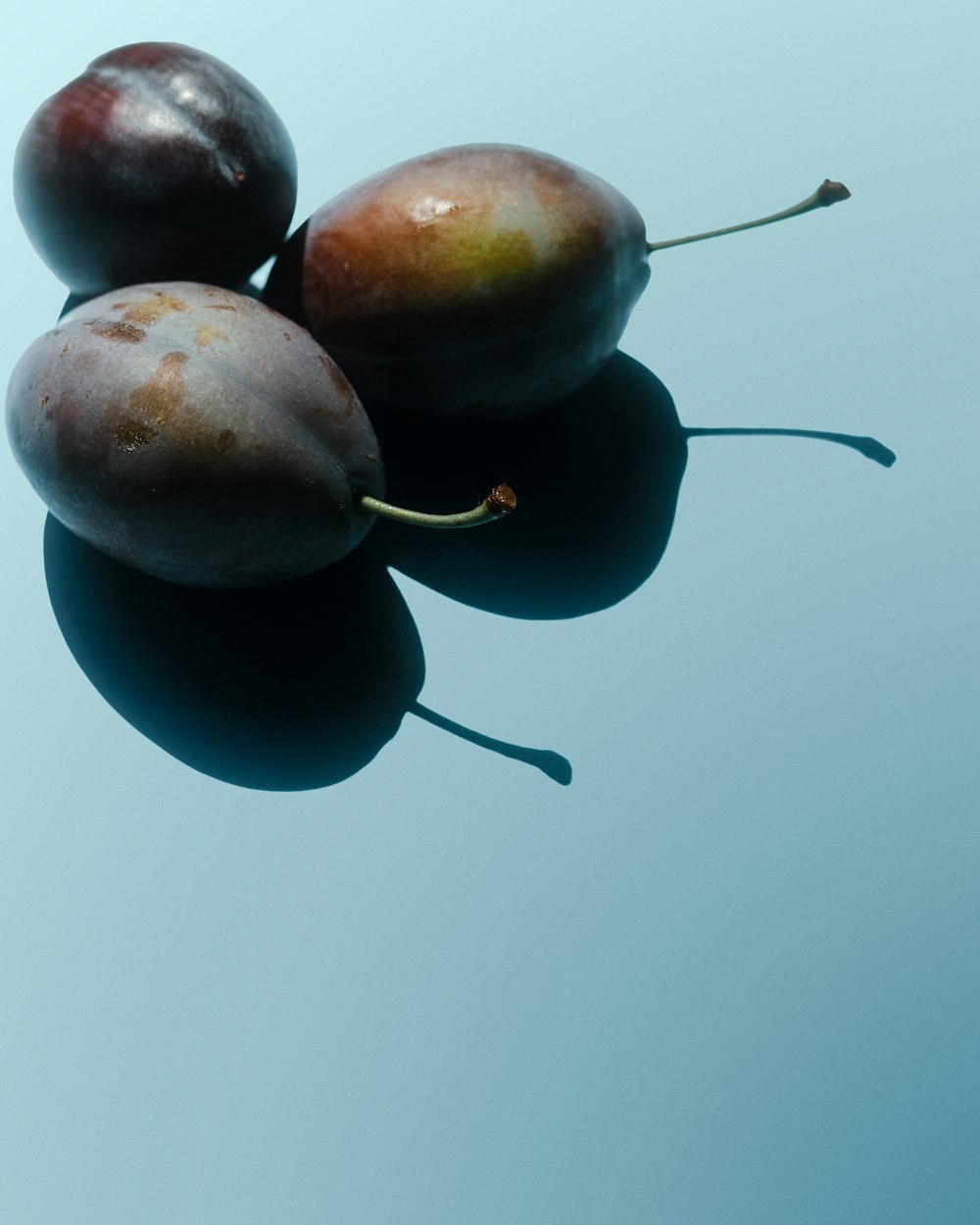 three plums sitting on top of each other on a table