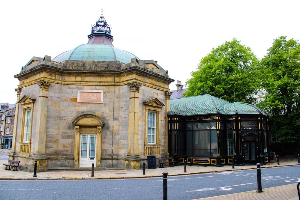 an old building with a green roof next to a street