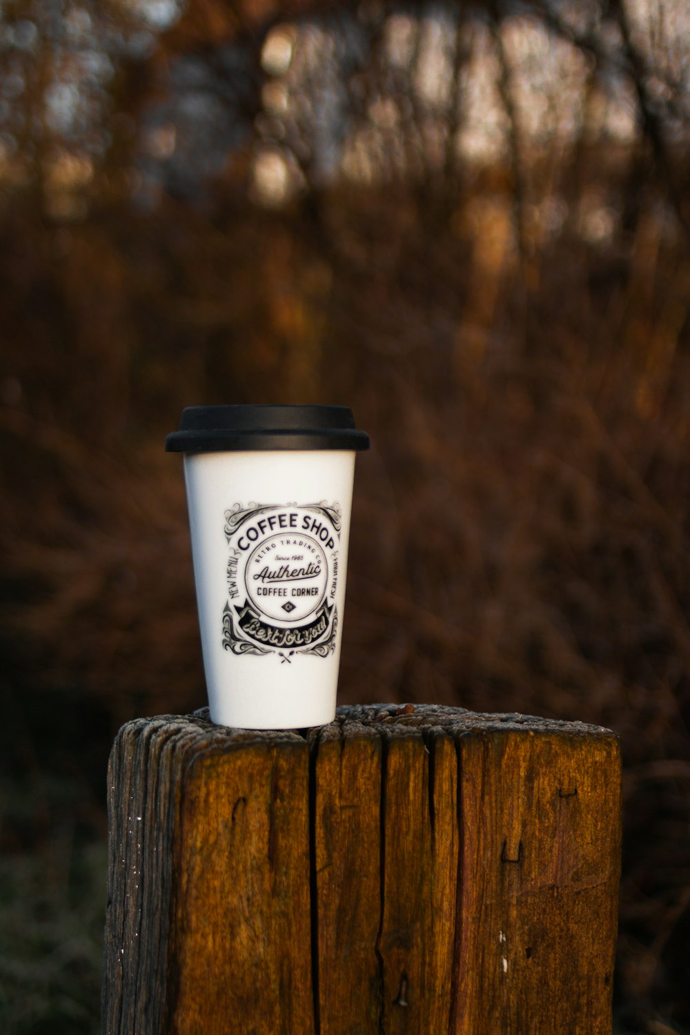 a cup of coffee sitting on top of a wooden post