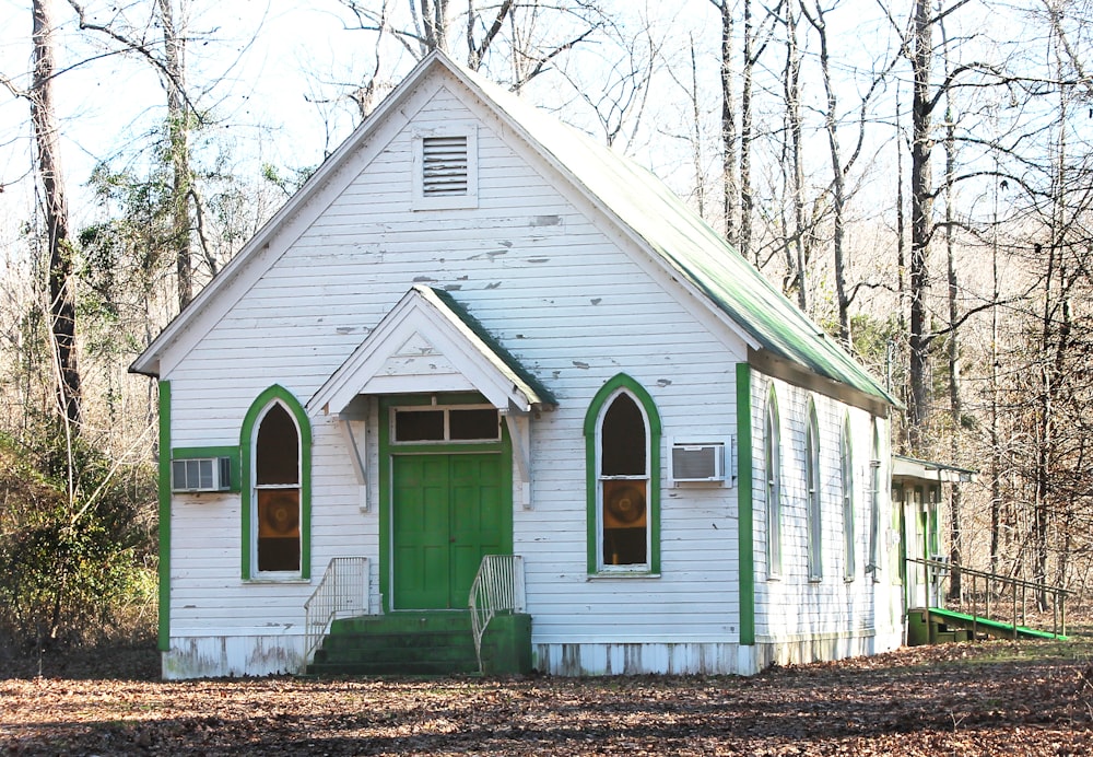 a small white church with a green door
