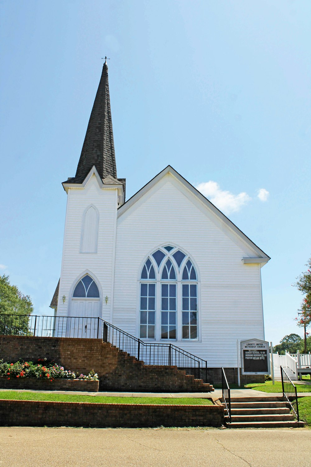 a white church with a steeple on a sunny day