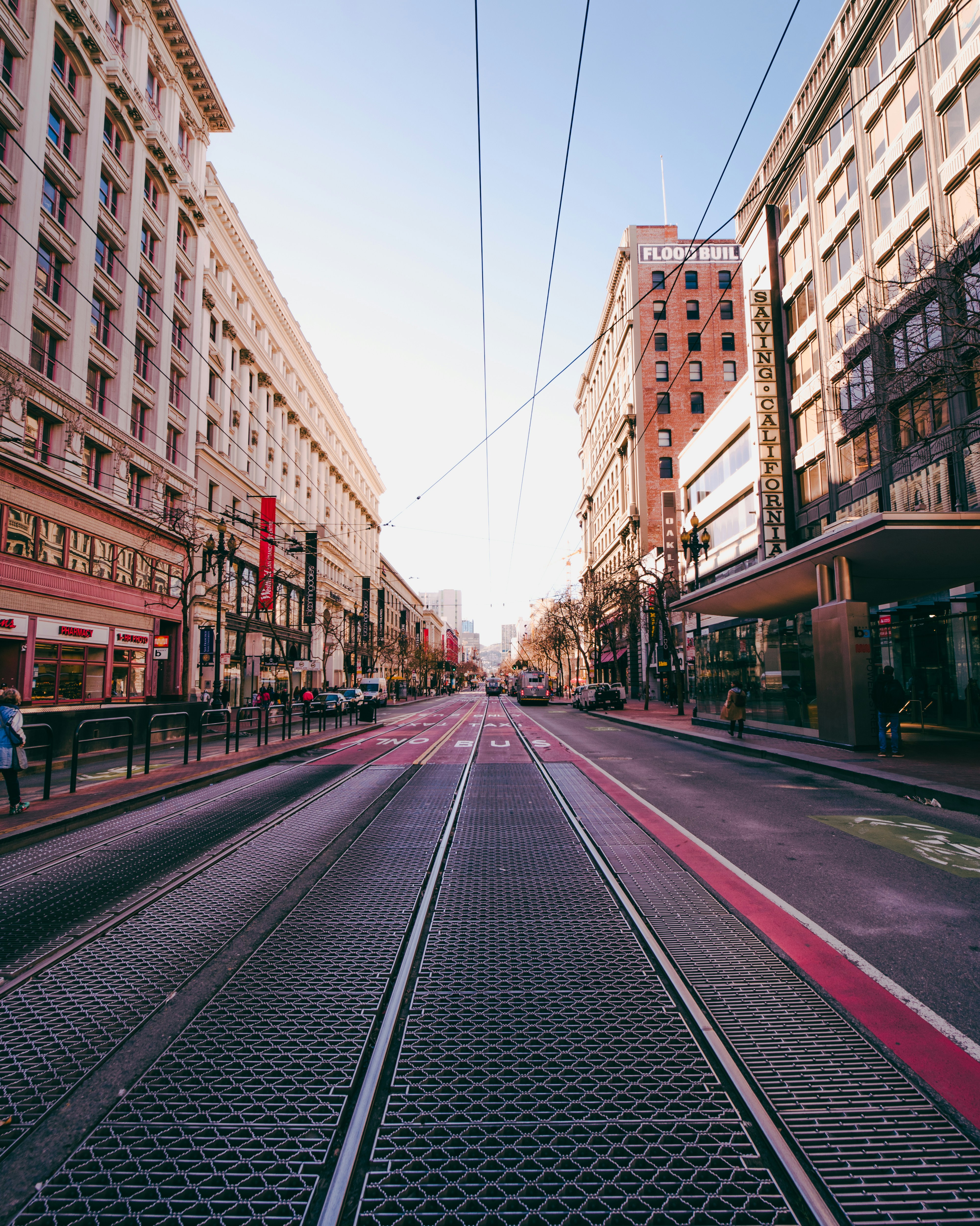 a city street with buildings and people walking on the sidewalk
