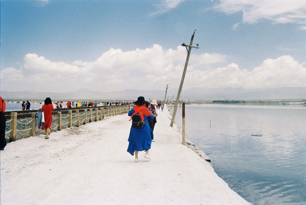 a group of people walking across a snow covered bridge