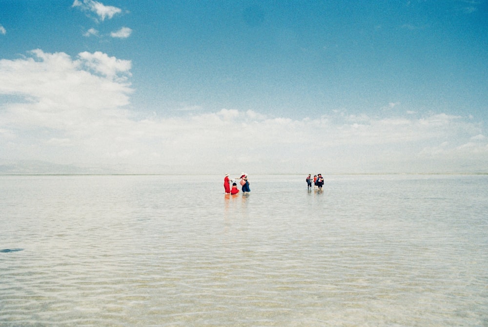 a group of people standing on top of a large body of water