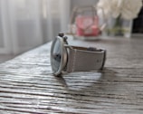 An elegant watch displayed on a wooden surface.
