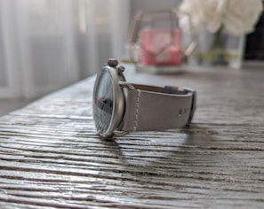 Close-up of a sleek modern watch with a leather strap on a wooden table