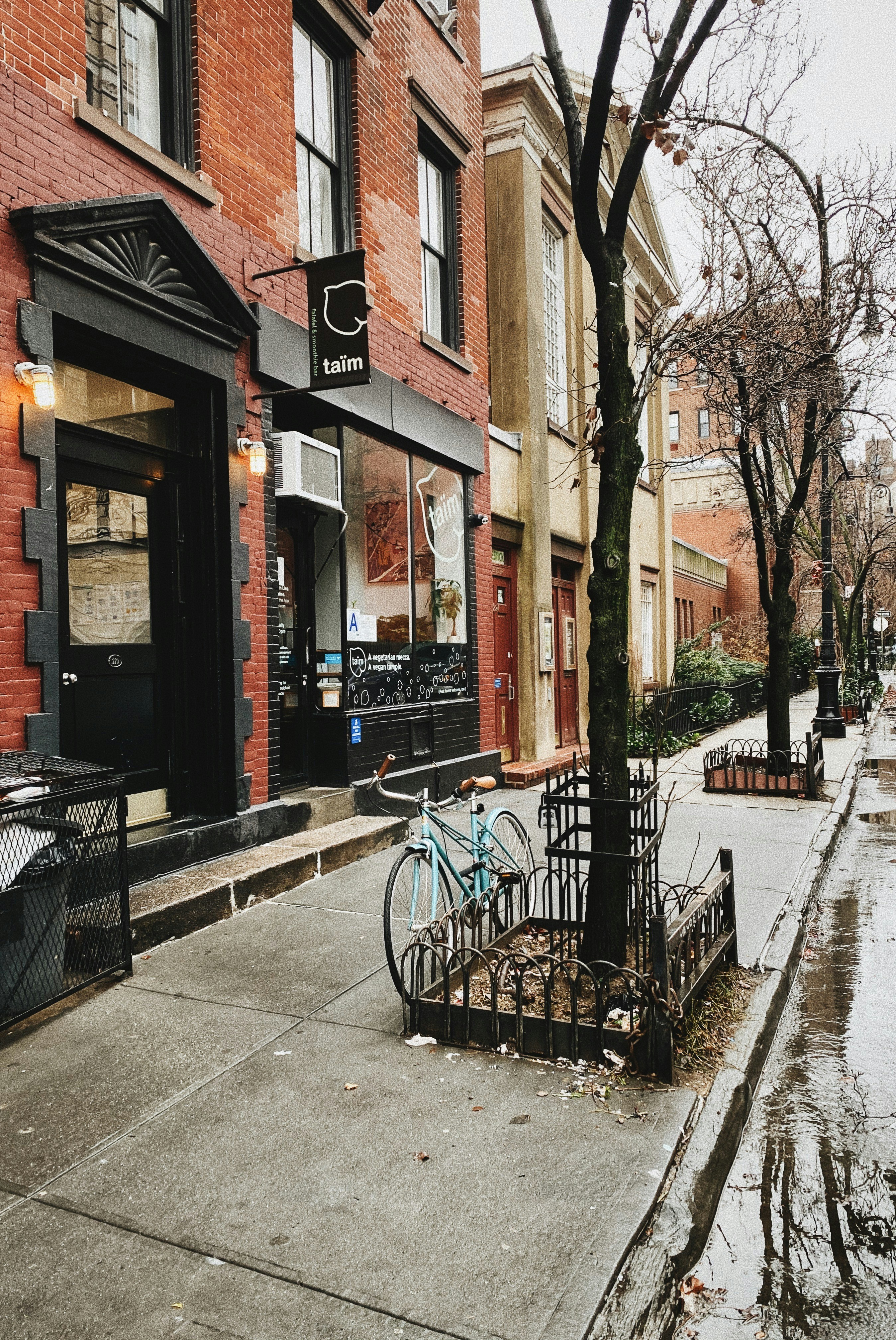 a bike parked on the side of a street next to a tree