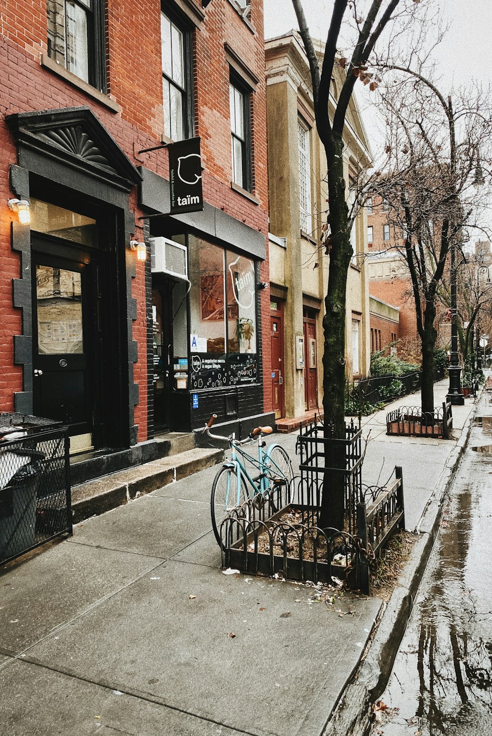 a bike parked on the side of a street next to a tree