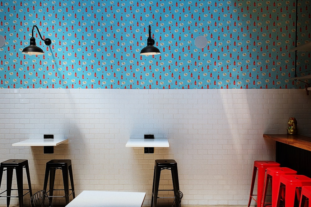 a room with three stools and a wall with birds on it