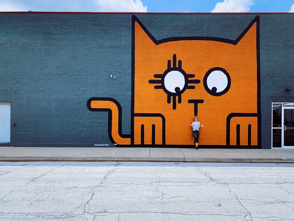 a large orange cat painted on the side of a building
