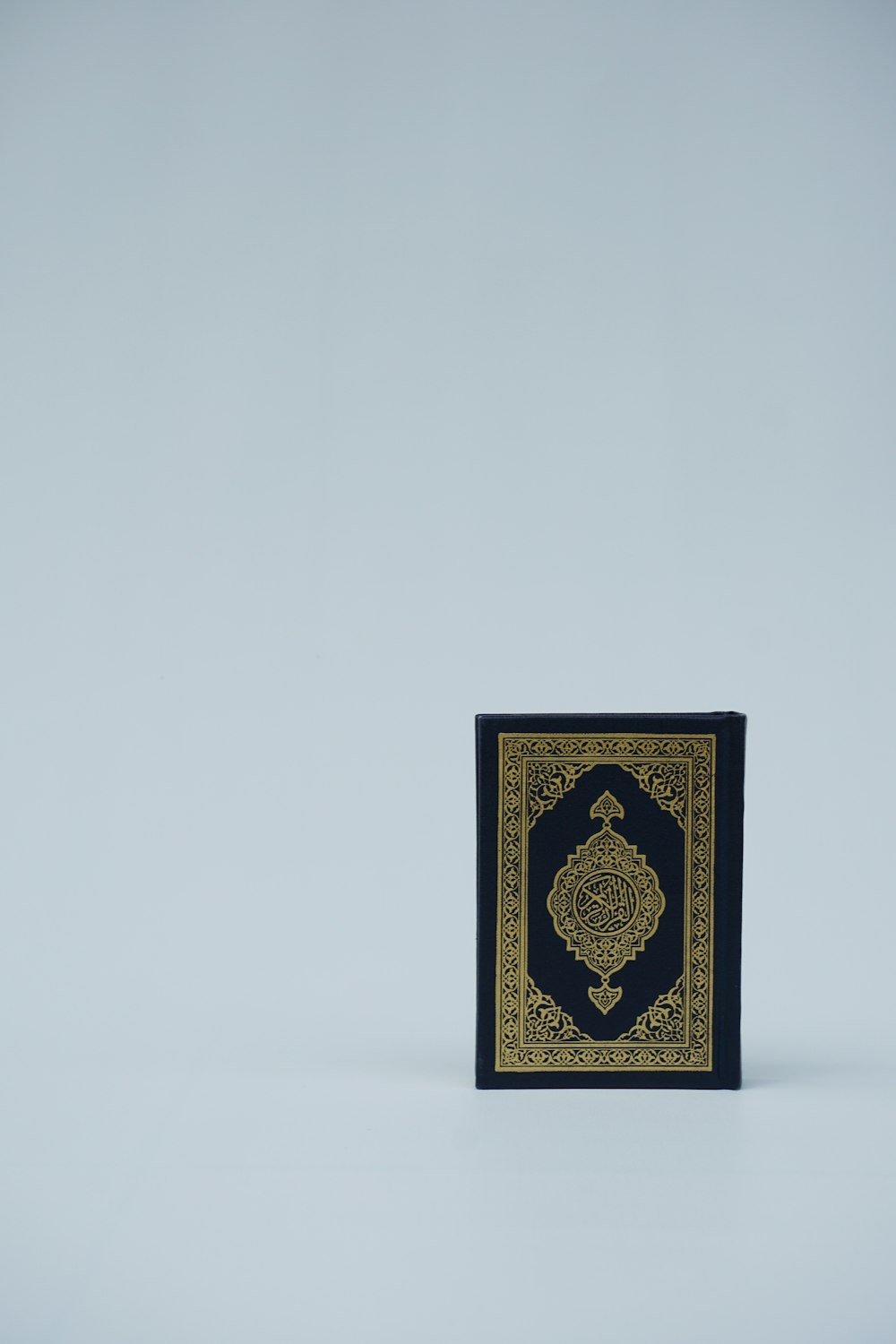 um livro preto e dourado sentado em cima de uma mesa
