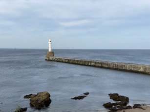 aberdeen scotland film production companies: light house sitting on top of a pier next to the ocean