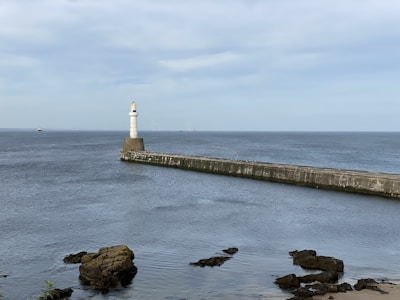 aberdeen scotland film production companies: light house sitting on top of a pier next to the ocean