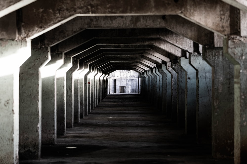 a tunnel of concrete with a light at the end