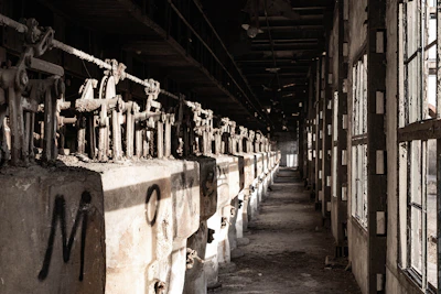 A wide shot of a dirty, neglected beverage filling line with visible leaks and corrosion.
