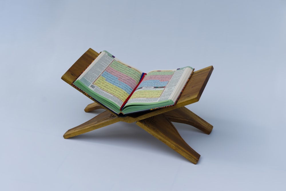 um livro aberto sentado em cima de um suporte de madeira