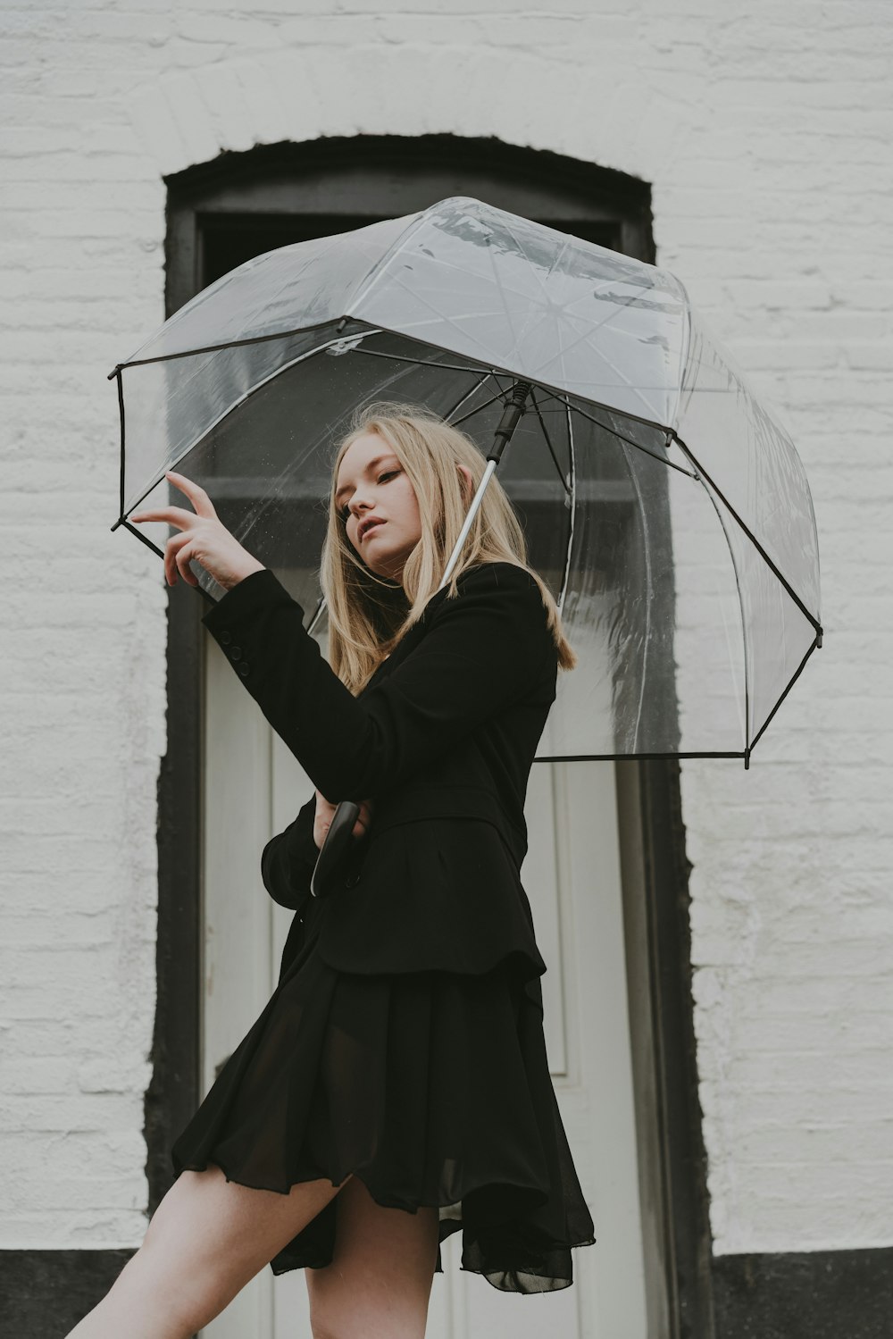 a woman in a black dress holding an umbrella