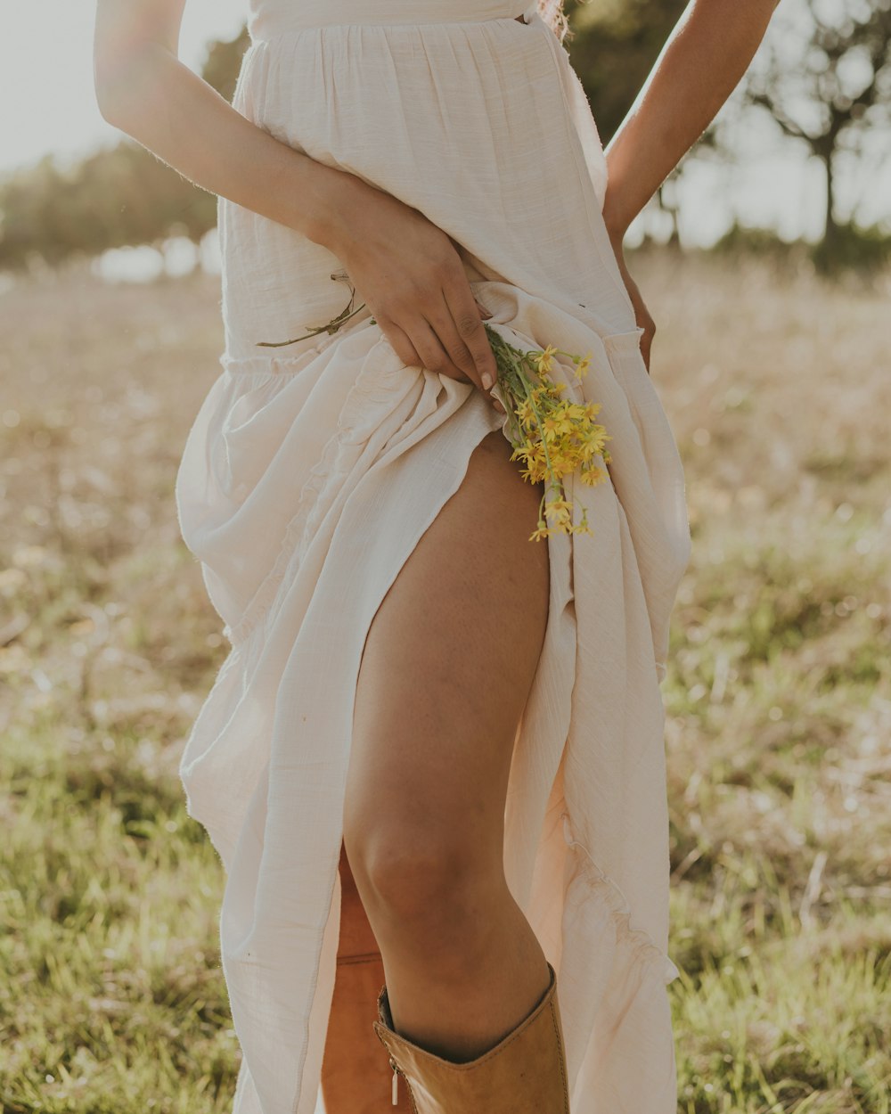 a woman in a white dress and cowboy boots