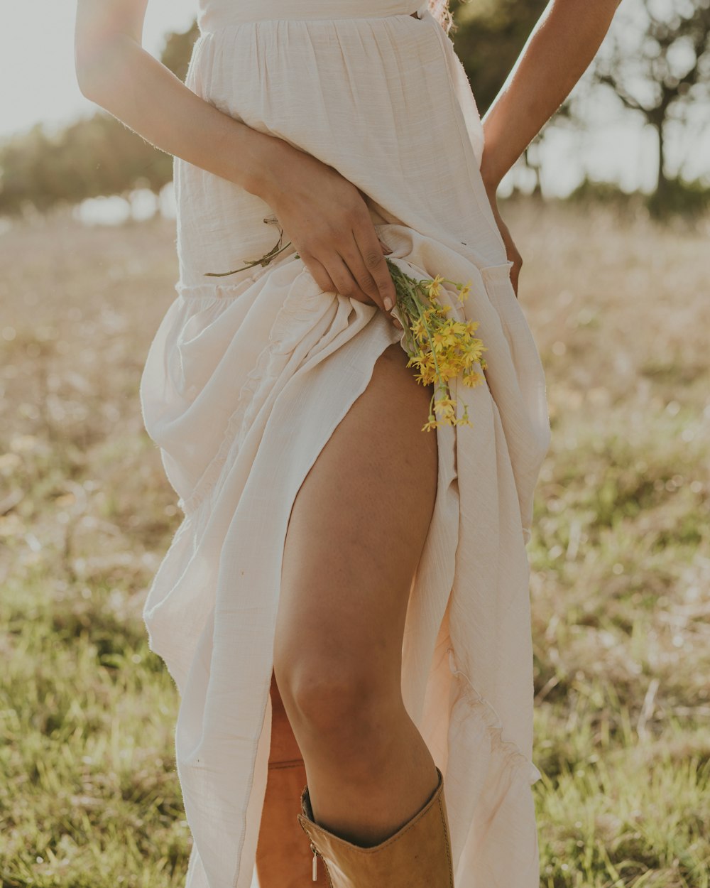 Eine Frau in weißem Kleid und Cowboystiefeln