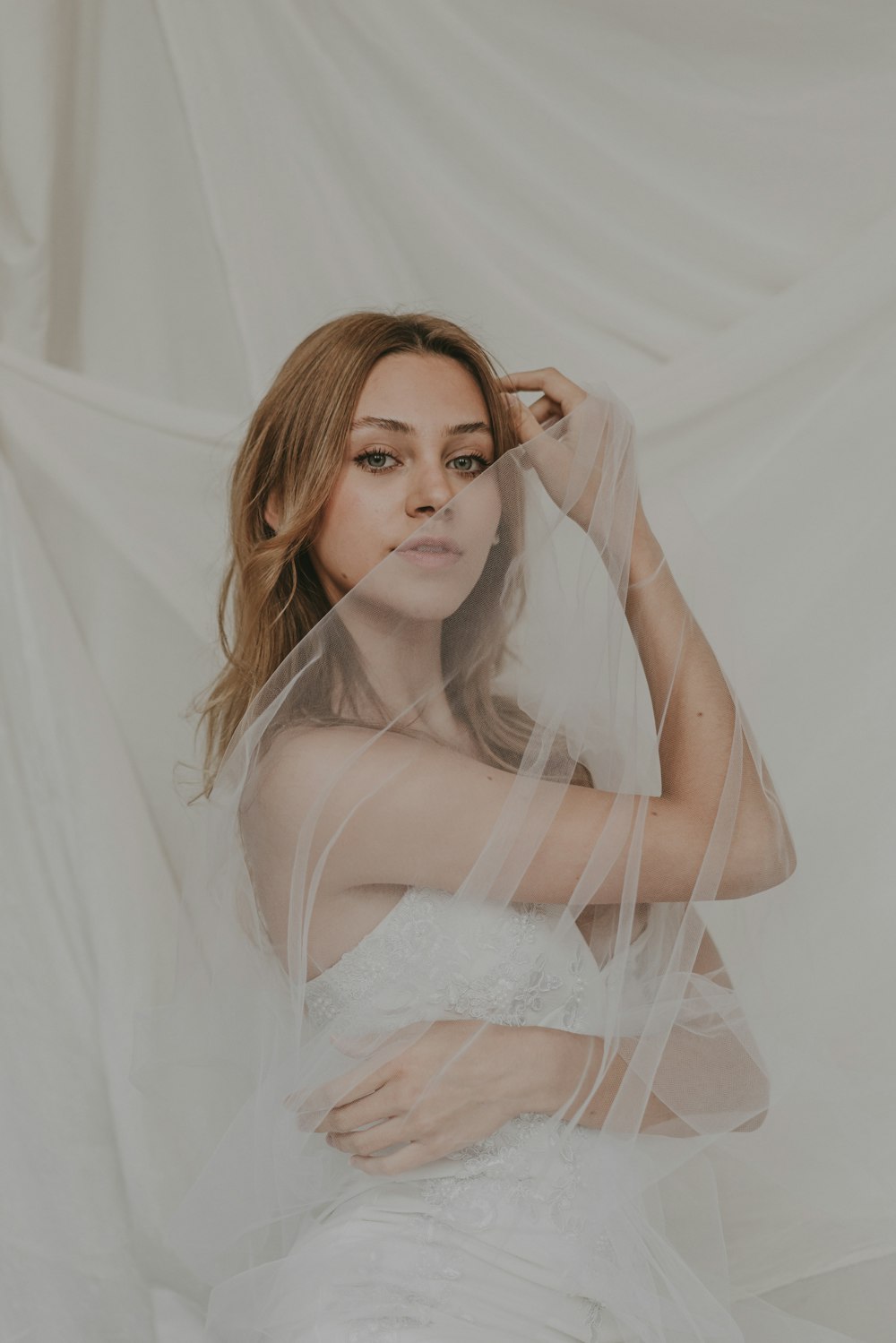 a woman in a wedding dress with a veil over her head