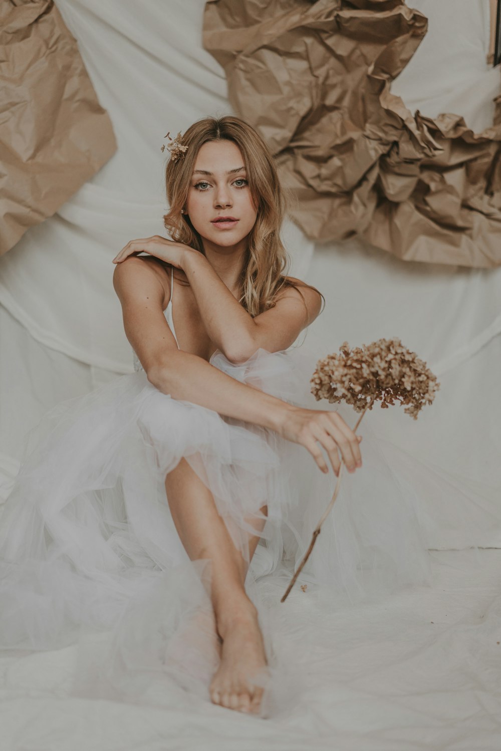 a woman in a white dress sitting on a chair