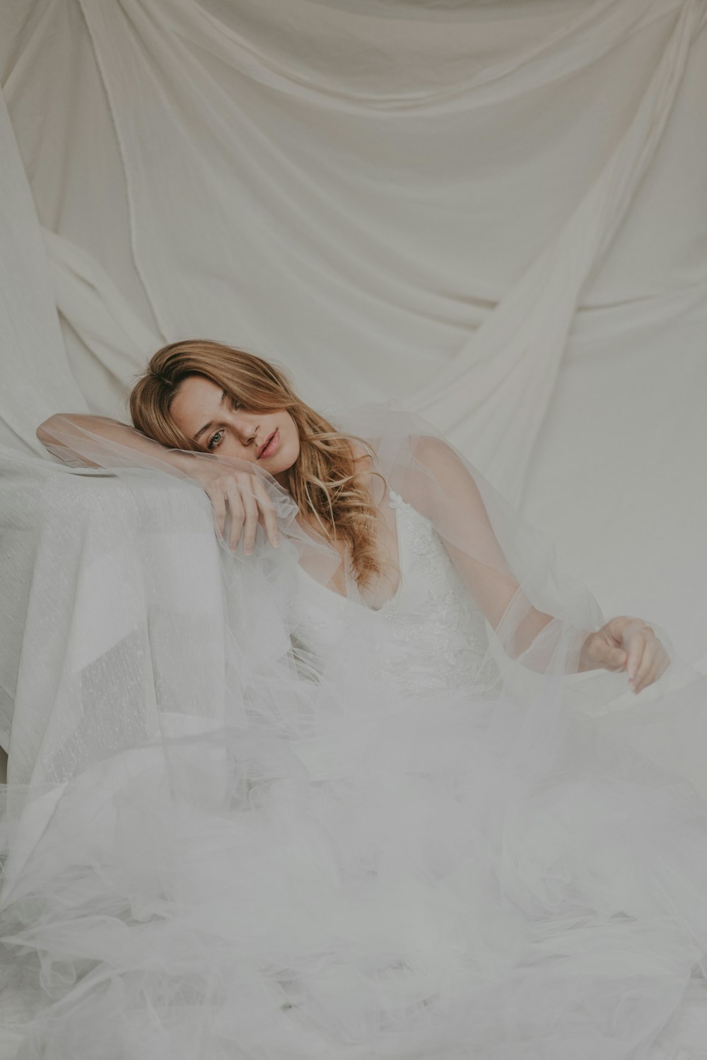 a woman in a white dress sitting on a chair