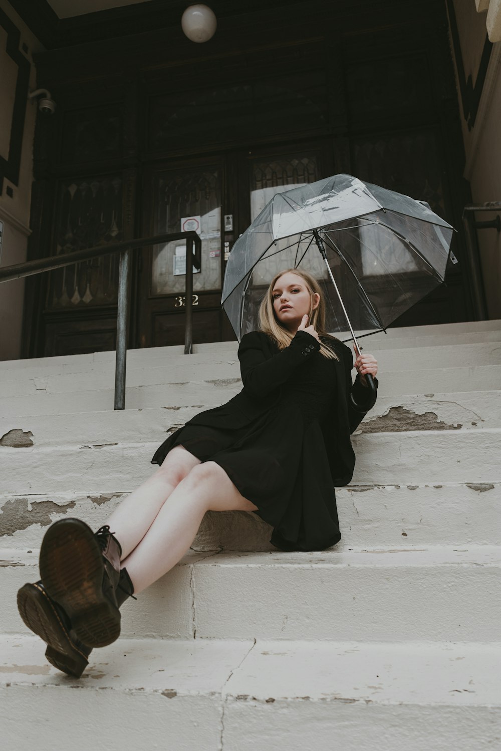a woman sitting on steps holding an umbrella