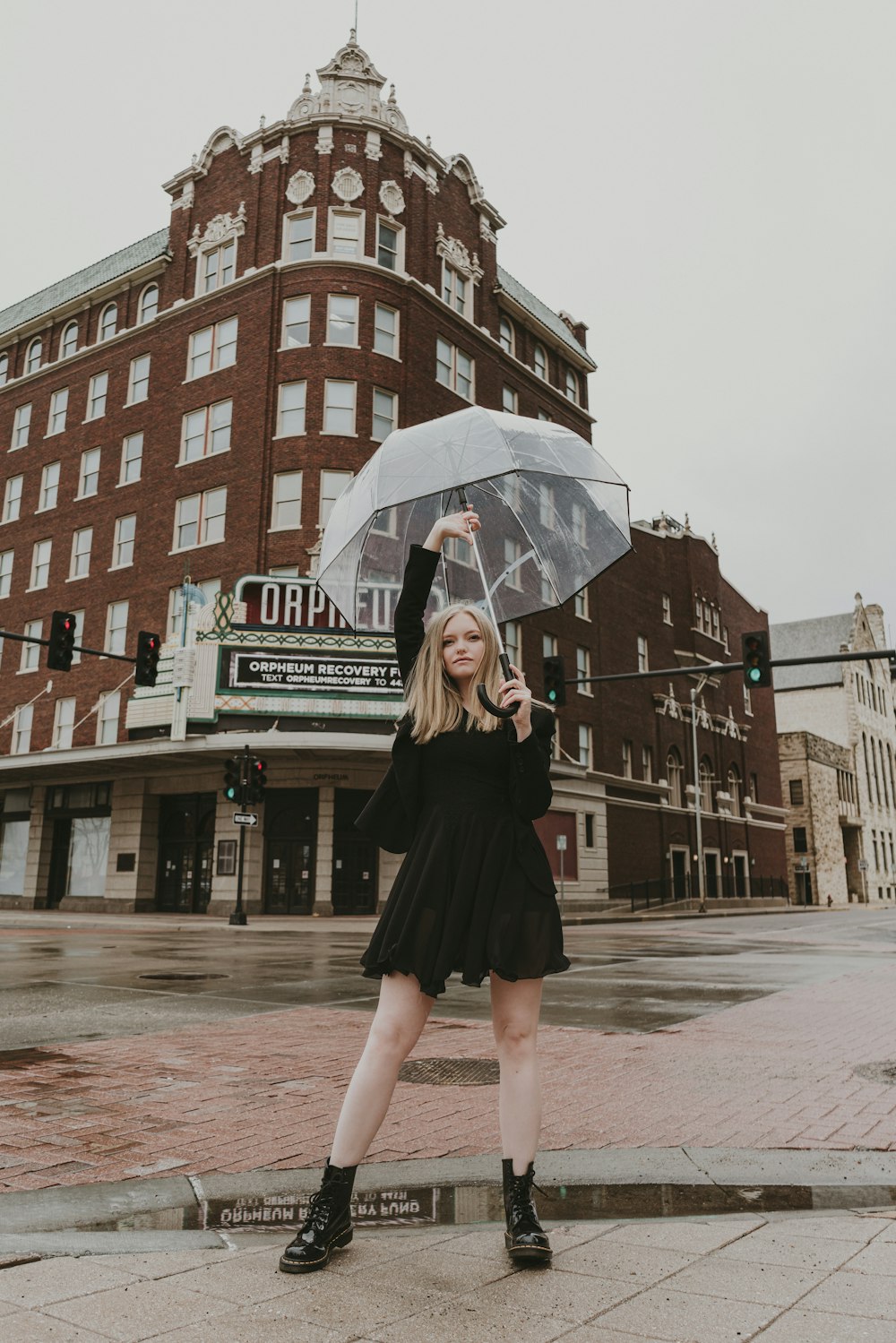 Eine Frau in einem schwarzen Kleid mit einem Regenschirm