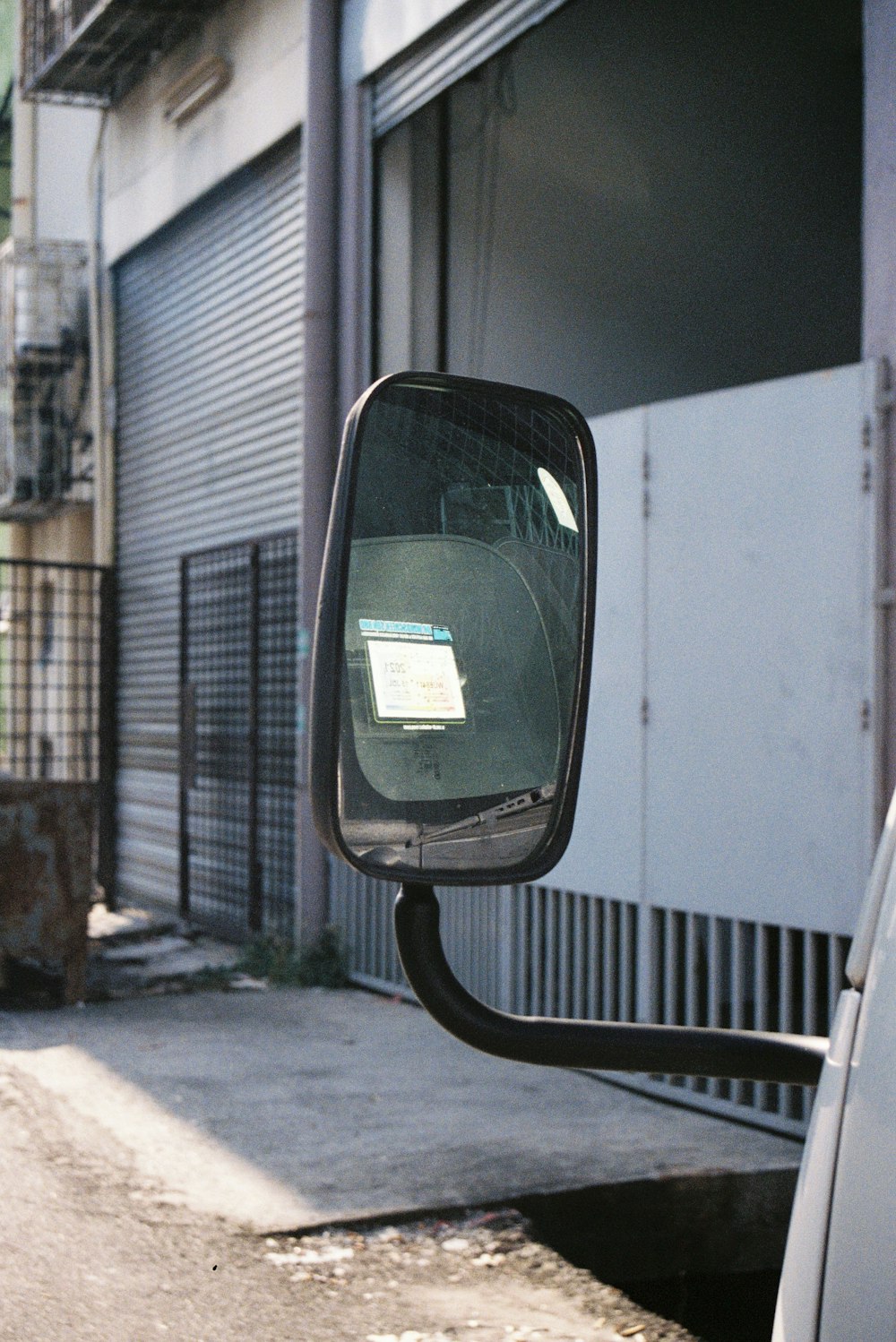 a rear view mirror of a car on the side of the road