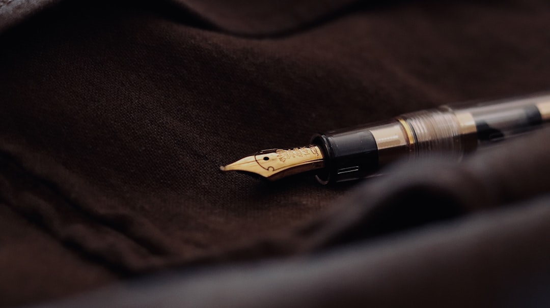 a fountain pen laying on a brown cloth,