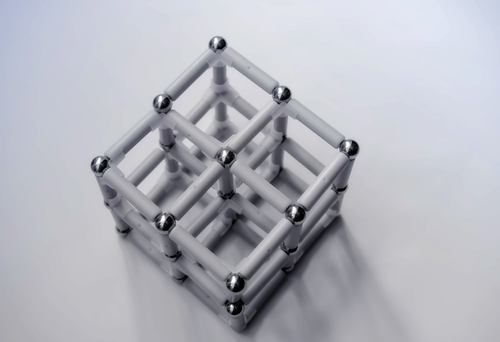 um cubo branco com bolas de metal nele