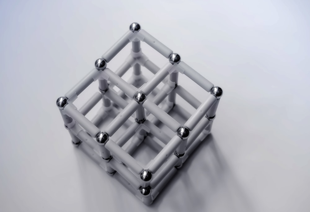 un cube blanc avec des billes métalliques dedans