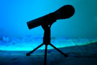 Abstract shadows cast by a microphone against a dark backdrop.