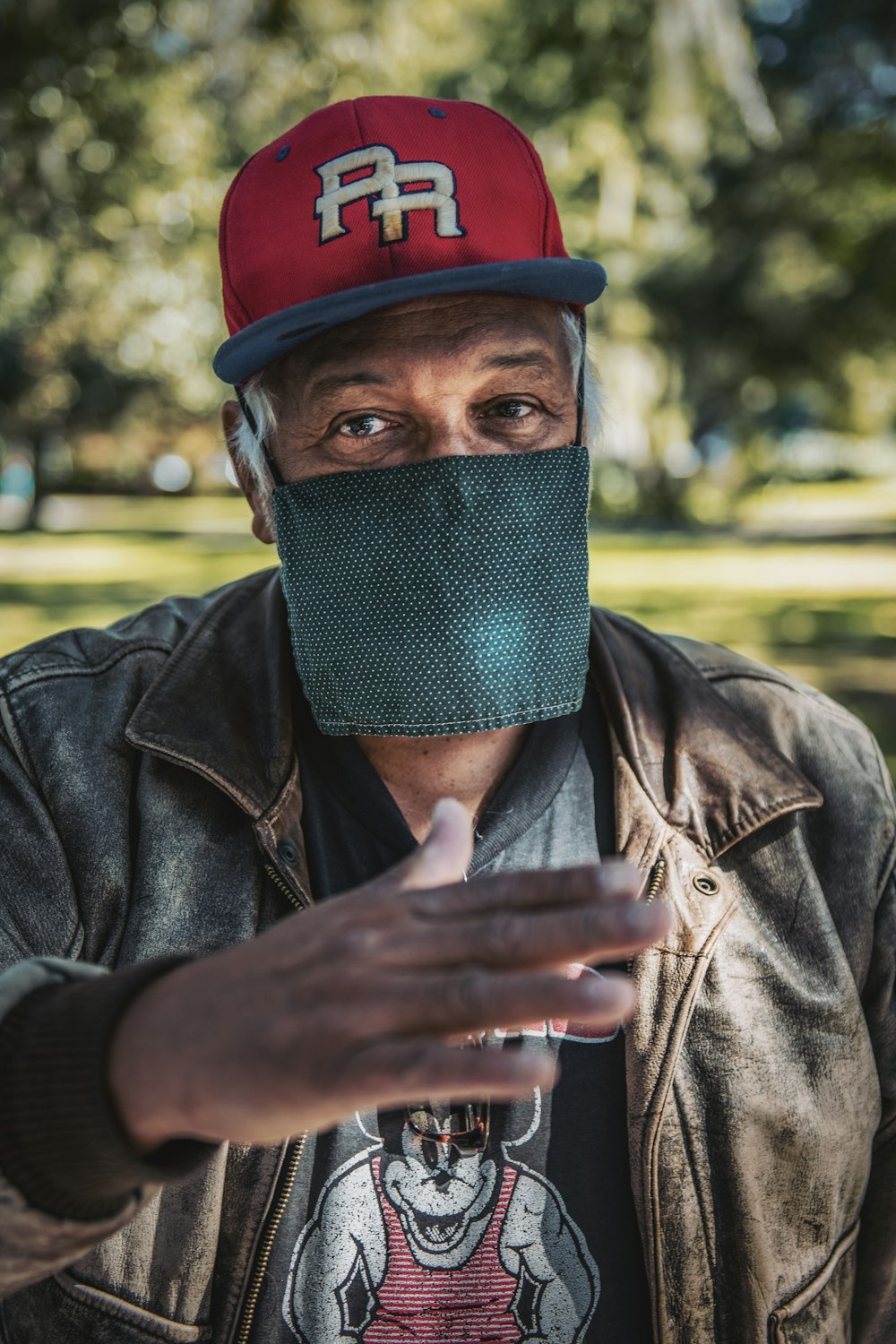 a man wearing a face mask and a leather jacket