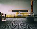 A modern living room featuring a blend of wallpaper and decorative clocks.