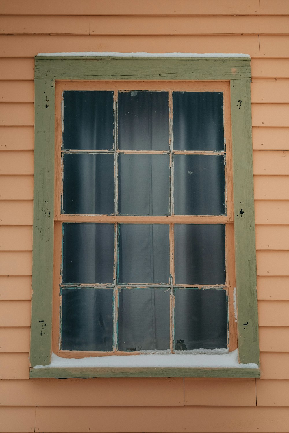a window with a green frame on the side of a building